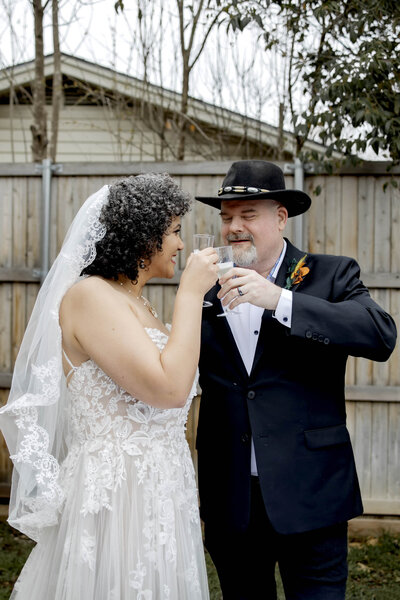 A Bride and Groom toast at a backyard wedding in Dallas Texas in Preston Hollow