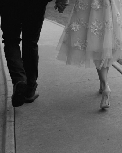 A bride and groom are walking away.