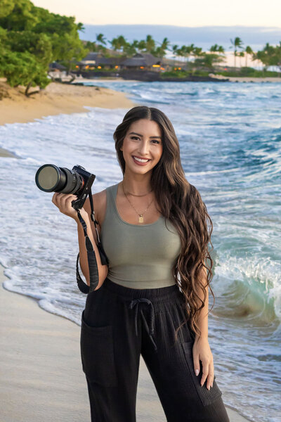 One of the best Hawaii big island photographers on beach holding camera