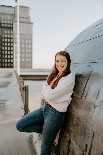 Jami Barry sits on a chair with her camera