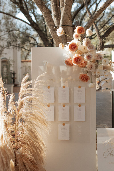 Customized calligraphy wedding seating chart with flowers nearby, representing full service design offerings by Life in Letters.