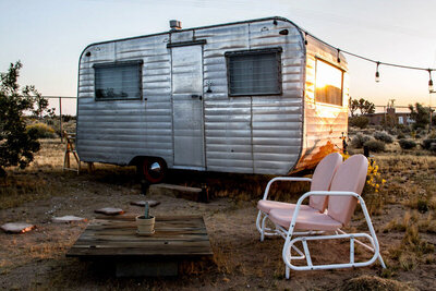 Location branding airbnb Gatos Trail Ranch mini metal trailer with patio chairs out front
