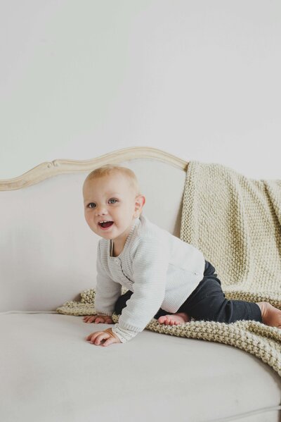 Young boy crawling on bed