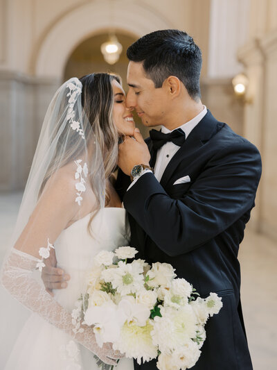 Napa wedding photographer sitting on a stool in a studio, holding a camera with a confident and welcoming expression, ready to capture timeless love stories.