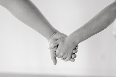 blue and white themed wedding photo of people holding hands 