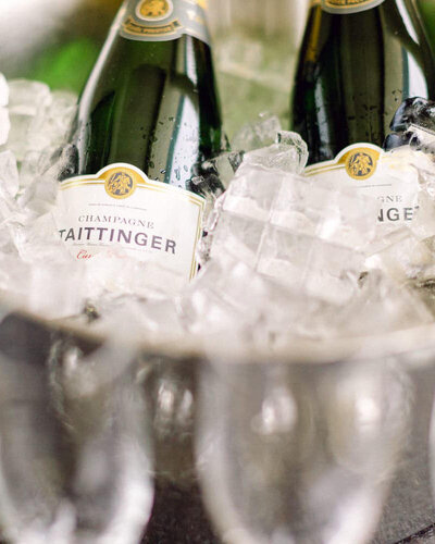 This elegant close-up photograph features bottles of champagne set aside for the bride and groom on their wedding day at Chateau Lake Louise. The sparkling bottles capture the celebration's spirit, adding a touch of luxury to the scenic and festive occasion.