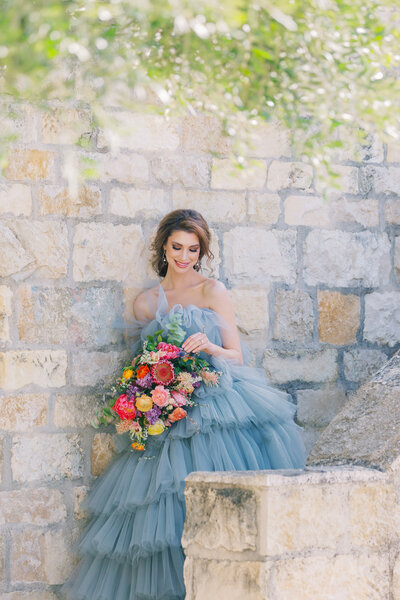 Portraits of Bride on her wedding day. She holds a colorful bouquet.