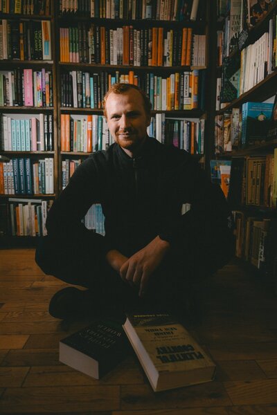 Wedding Photographer Connor Esau sitting in a book store