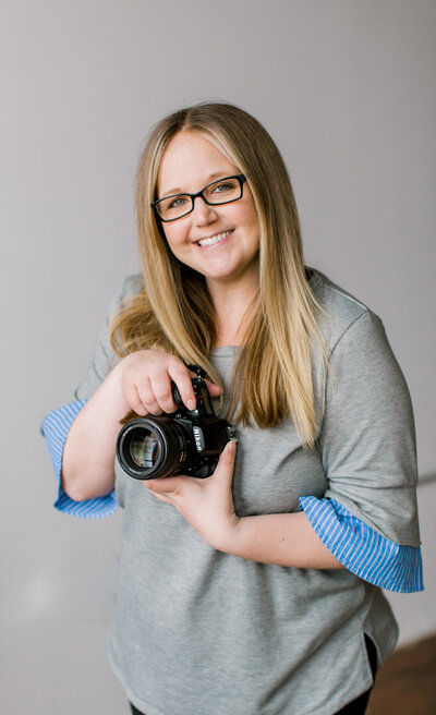 Jennifer Maren smiles while holding camera
