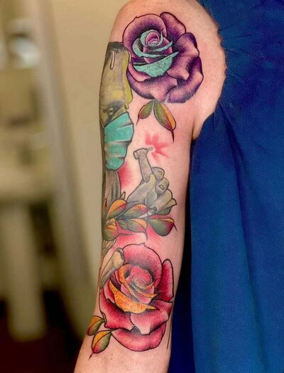 colored rose tattoo on upper arm