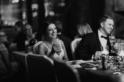 Bride smiling during wedding reception toast - Alex Bo Photo