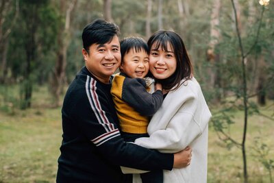 Man spinning woman in floral dress around outside in bush, dancing during a couples photography session, And So I Don't Forget Photography