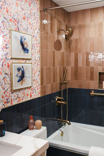 Shower and tub with blush pink and emerald tile, brushed gold fixtures and floral wallpaper