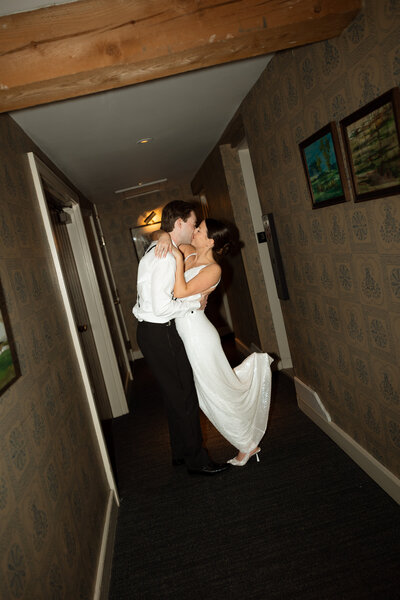 Couple embracing in hotel hall after a quick outfit change for the reception | New Hampshire Wedding