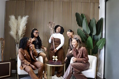 women on the board of directors for Black Girls Lax Too, some seated, one holding lacrosse stick