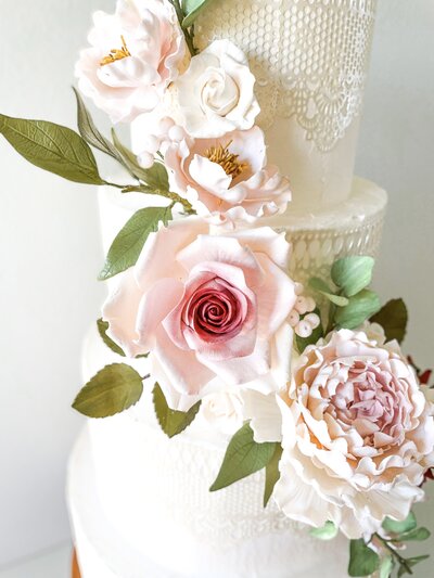 wedding cake with dusty pink and burgundy roses and peonies