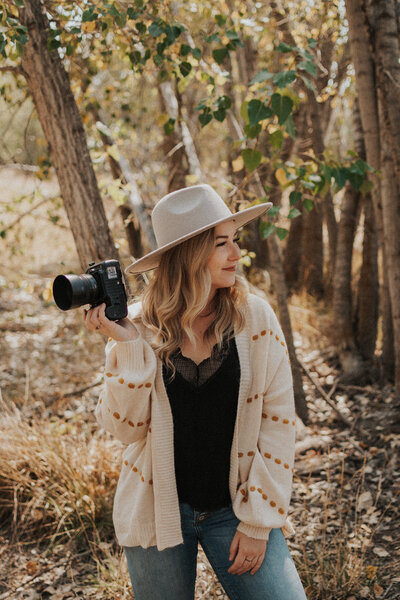 Woman holding a camera standing outside