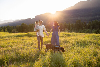 family at sunset in front of floral bushes being photographed by a Portland family photographer