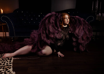 woman wearing black lingerie and angel wings during boudoir session