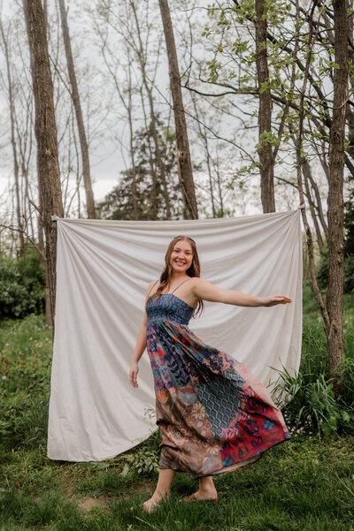 Teen girl captured by the camera mid-twirl in a boho dress.