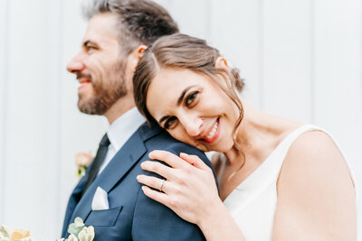 Bride leans her head on her grooms shoulder and smiles
