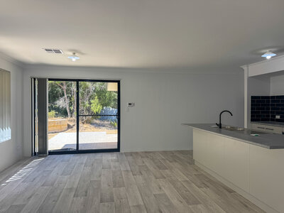 New home kitchen with off white walls, black windows and light grey wooden flooring in Dawesville