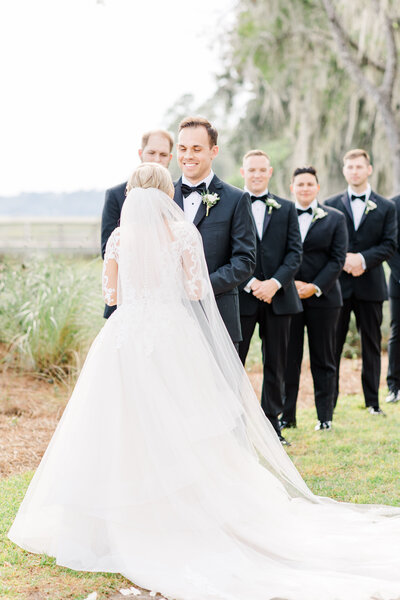 bride and groom kissing by vintage car after wedding