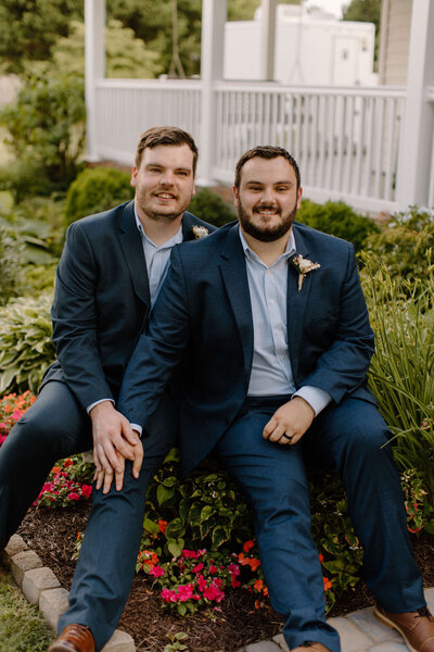 two grooms male wedding portraits near flowers at backyard wedding in delaware by sabrina leigh