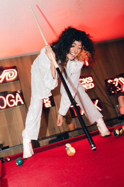 woman standing on a pool table
