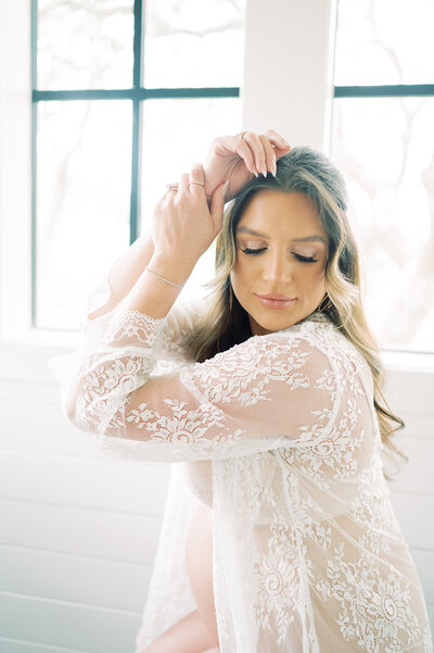 A mother in a lace coverup during an intimate maternity session