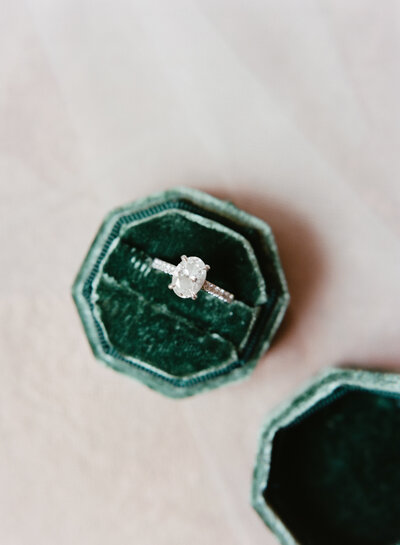 three stone diamond ring with infinity diamond band close up shot with grooms wedding band Folktale Winery Carmel California