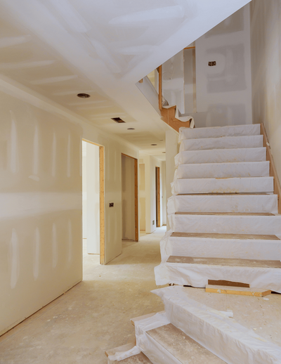 New home construction in progress featuring framed walls, drywall installation, and staircase preparation—showcasing expert craftsmanship and attention to detail from start to finish.