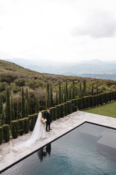 Bride and groom walking poolside at their Big Sky Montana wedding photographed by Best montana wedding photographer