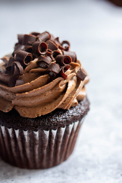 Chocolate cupcake with chocolate icing and curled chocolate shavings