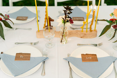 Wedding tablescape with blue napkins and wavy yellow candles