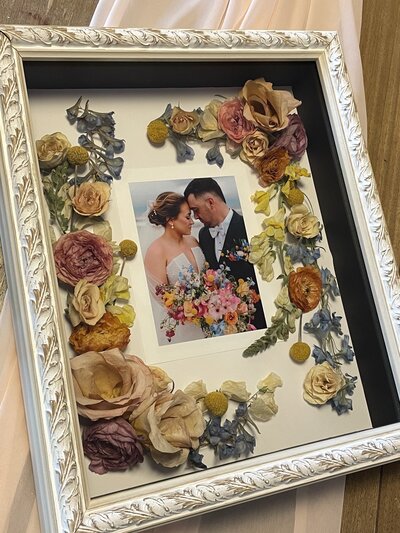 Elegant wedding flower preservation by Leigh Florist with blooms arranged in a clear display frame.