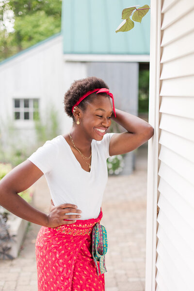 Senior girl resting her elbow on a building while laughing. Photo taken by Marysville, OH senior photographer Amanda Lauren Collective