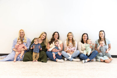 Group of women sitting on the floor while holding their babies