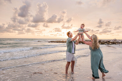 Family laughs during photo shoot at Sunset Beach on Treasure Island