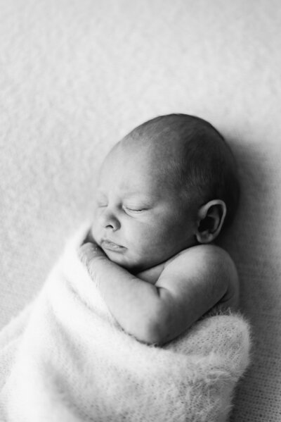 Newborn in mums arms during a natural newborn photoshoot in Billingshurst