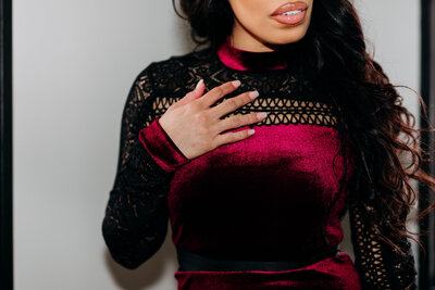 Close up photo of a woman's hand on her red and black dress