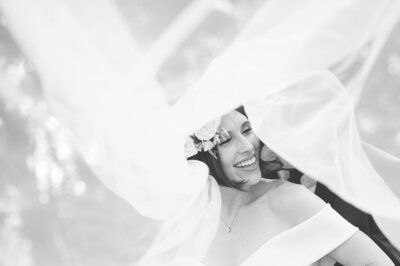 black and white Ottawa wedding photography showing a bride and groom laughing under a veil