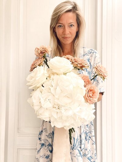 Flower Stylist Michèle heeft een romantisch boeket vast met witte hortensia's, roze rozen en roze anjers