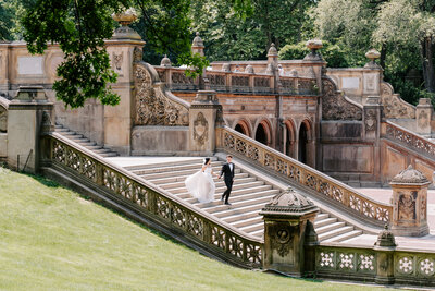 newlyweds walking down steps at Bethesda Terrace