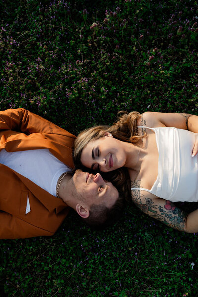 couple cuddling on ground for engagement session