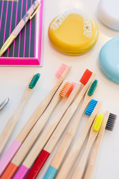 Flatlay of colorful wooden toothbrushes and assorted orthodontic tools