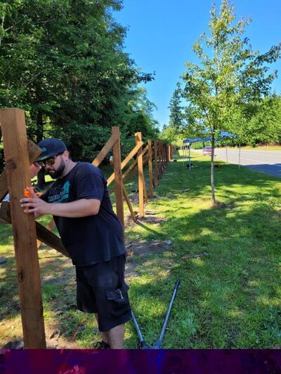 A deck contractor leveling a fence beam