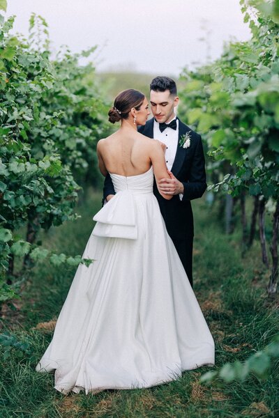 A bride and groom sharing an intimate moment between columns, captured by a Luxury Wedding Photographer.