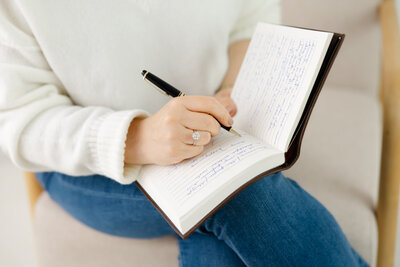 Woman writing in journal symbolizing reflection and mindful leadership growth