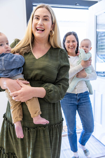 Women smiling as they hold their babies